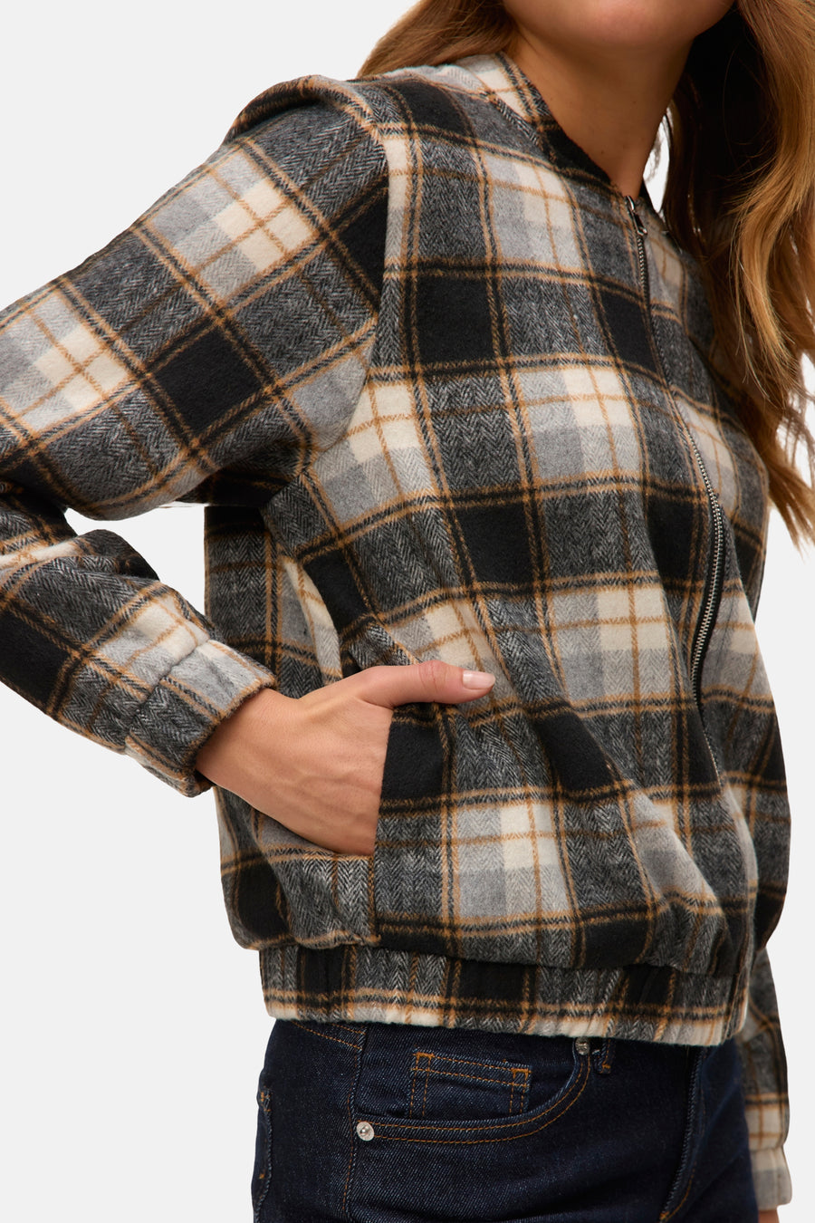 Korte meerkleurige jas van VERO MODA met ruitpatroon en ritssluiting, gedragen met een donkerblauwe jeans.