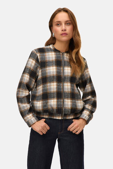 Kort geruit jasje van VERO MODA, gedragen met een donkerblauwe jeans, vrouw met lang, krullend haar.