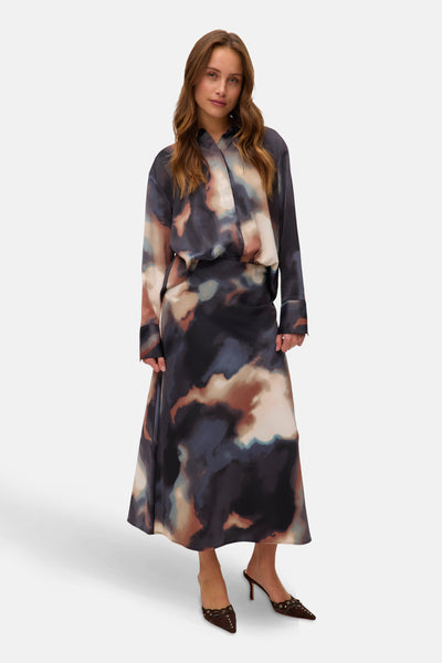 Jupe longue multicolore de VERO MODA, avec un imprimé artistique et des chaussures à talons marron.

