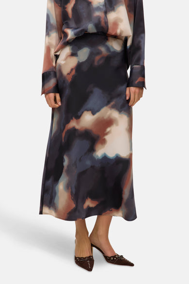 Multikleurige lange rok van VERO MODA, abstract patroon, met een paar bruine pumps met kleine strikjes.