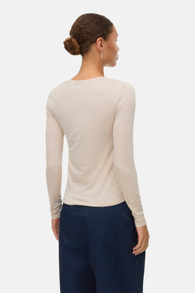 Beige blouse met lange mouwen van VERO MODA, met geribbelde textuur, gedragen met een effen marineblauwe broek.