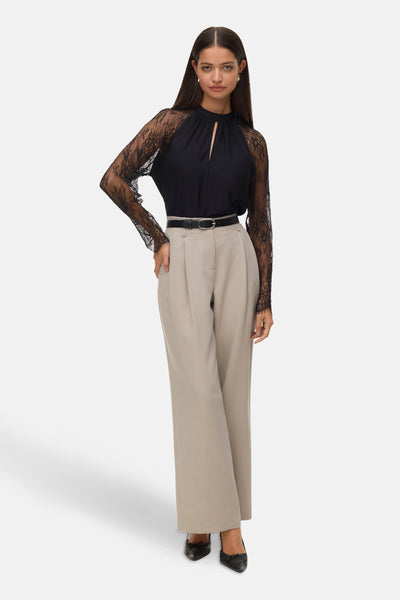 Zwarte blouse met lange mouwen van kant van VERO MODA, gedragen met een zwarte riem en een beige broek.
