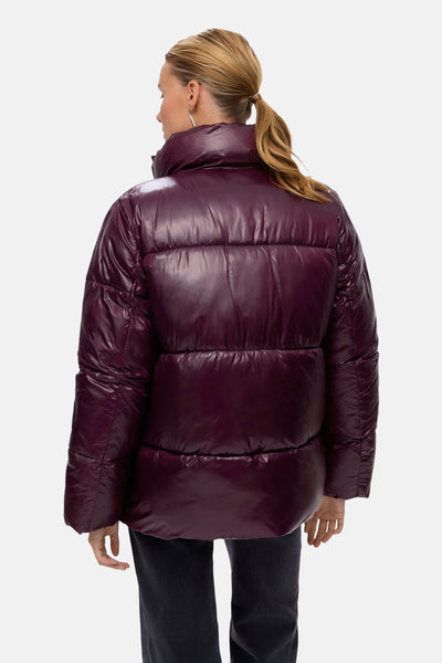 Veste courte rouge de Vero Moda, modèle matelassé à col montant, portée avec un jean noir.
