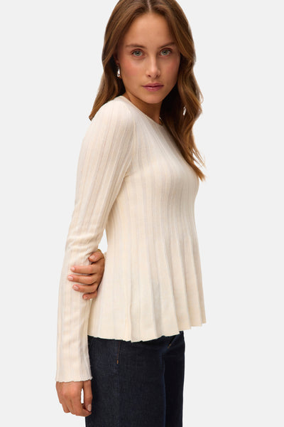 Beige ronde hals trui van VERO MODA® met geribbelde textuur en uitlopende pasvorm, gedragen met een donkere jeans.