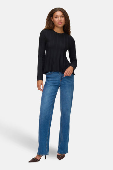 Zwarte rondehals trui van VERO MODA®, met lange mouwen, gedragen met een blauwe spijkerbroek en bruine hakken.