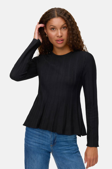 Zwarte rondehals trui van VERO MODA, gedragen met een blauwe jeans, lange mouwen en uitlopende pasvorm.
