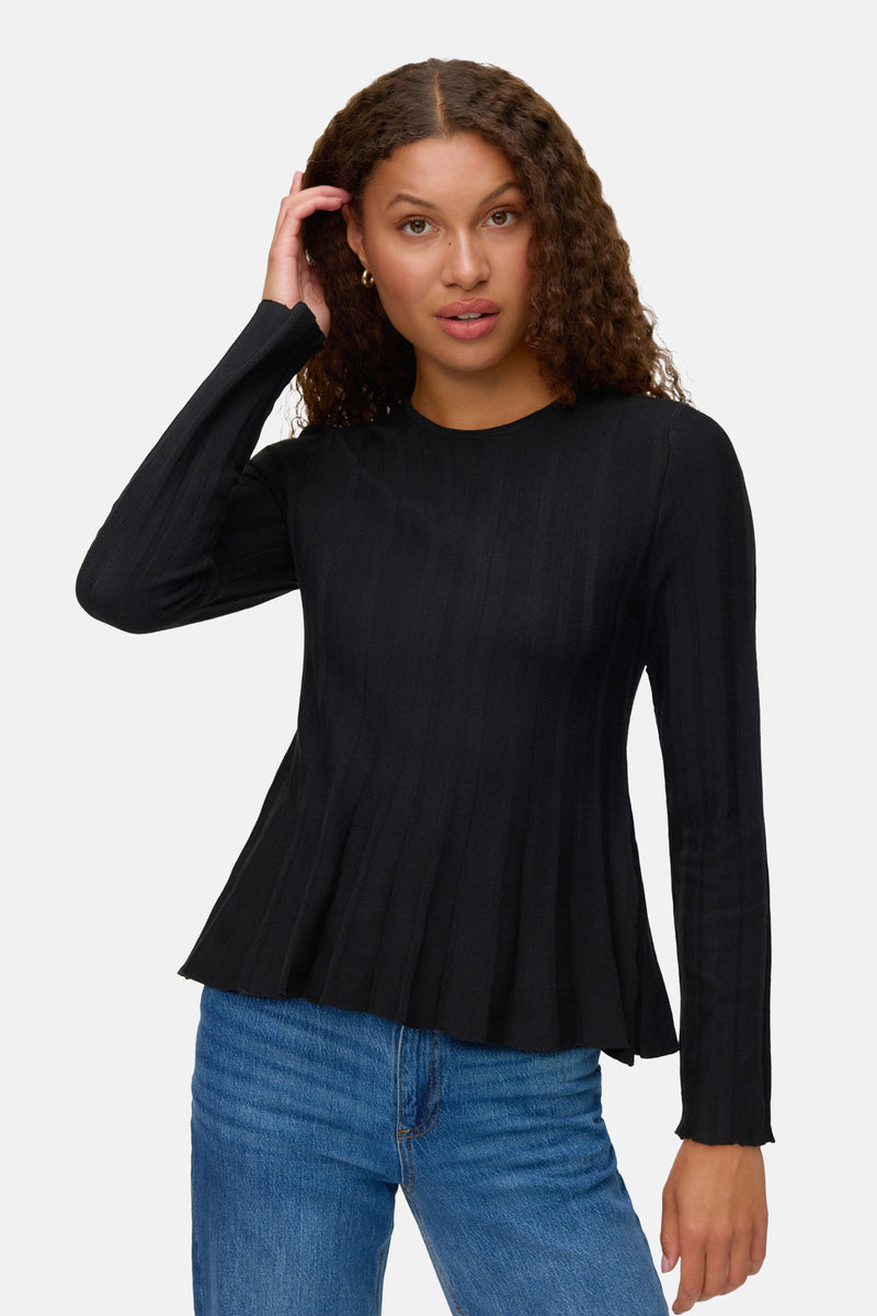 Zwarte rondehals trui van VERO MODA, gedragen met een blauwe jeans, lange mouwen en uitlopende pasvorm.