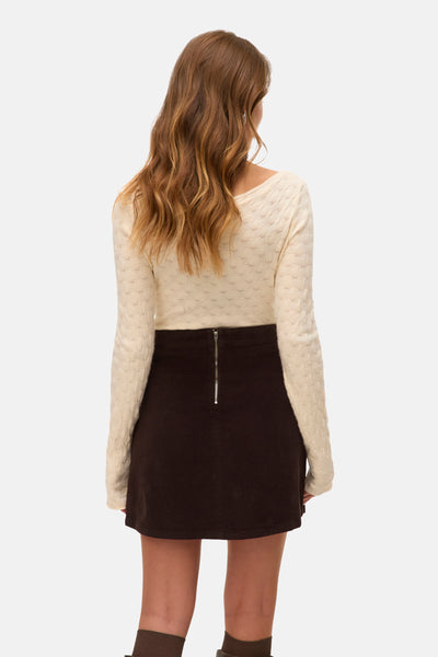 Beige ronde hals trui van VERO MODA®, met gebreide textuur en lange mouwen, gedragen met een bruine rok.