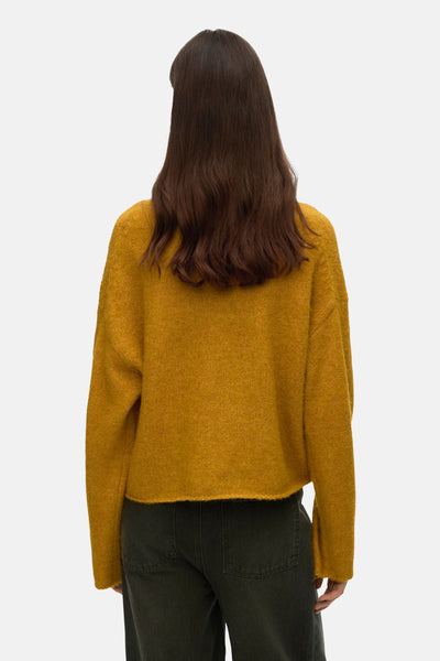 Gele coltrui van VERO MODA®, gedragen met een donkergroene broek, achterzicht.