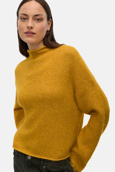 Pull à col roulé jaune de VERO MODA, en tricot texturé, porté avec un jean foncé.
