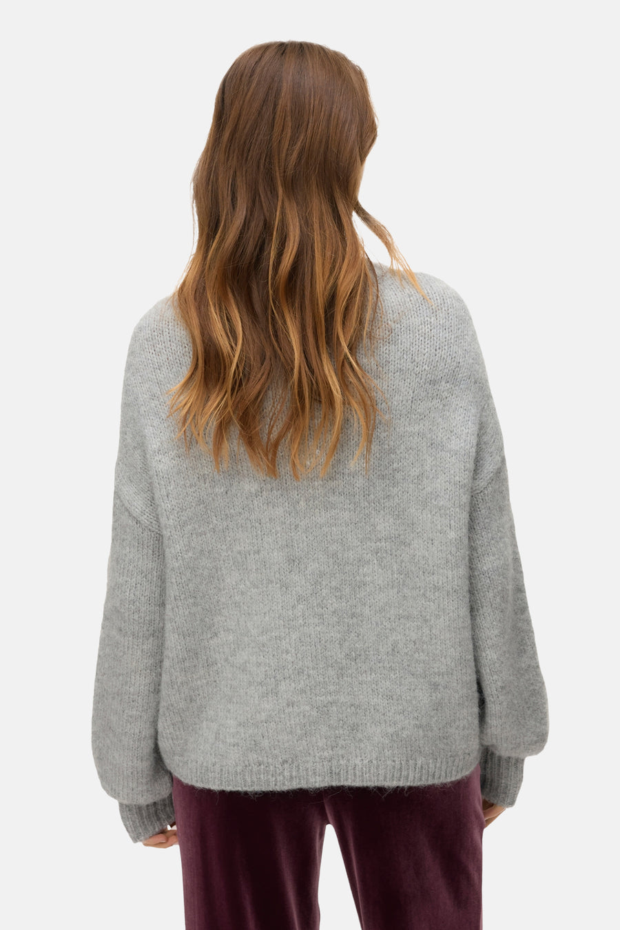 Grijze rondehals trui van VERO MODA, met een zachte textuur en lange mouwen, gedragen met een bordeauxrode broek.