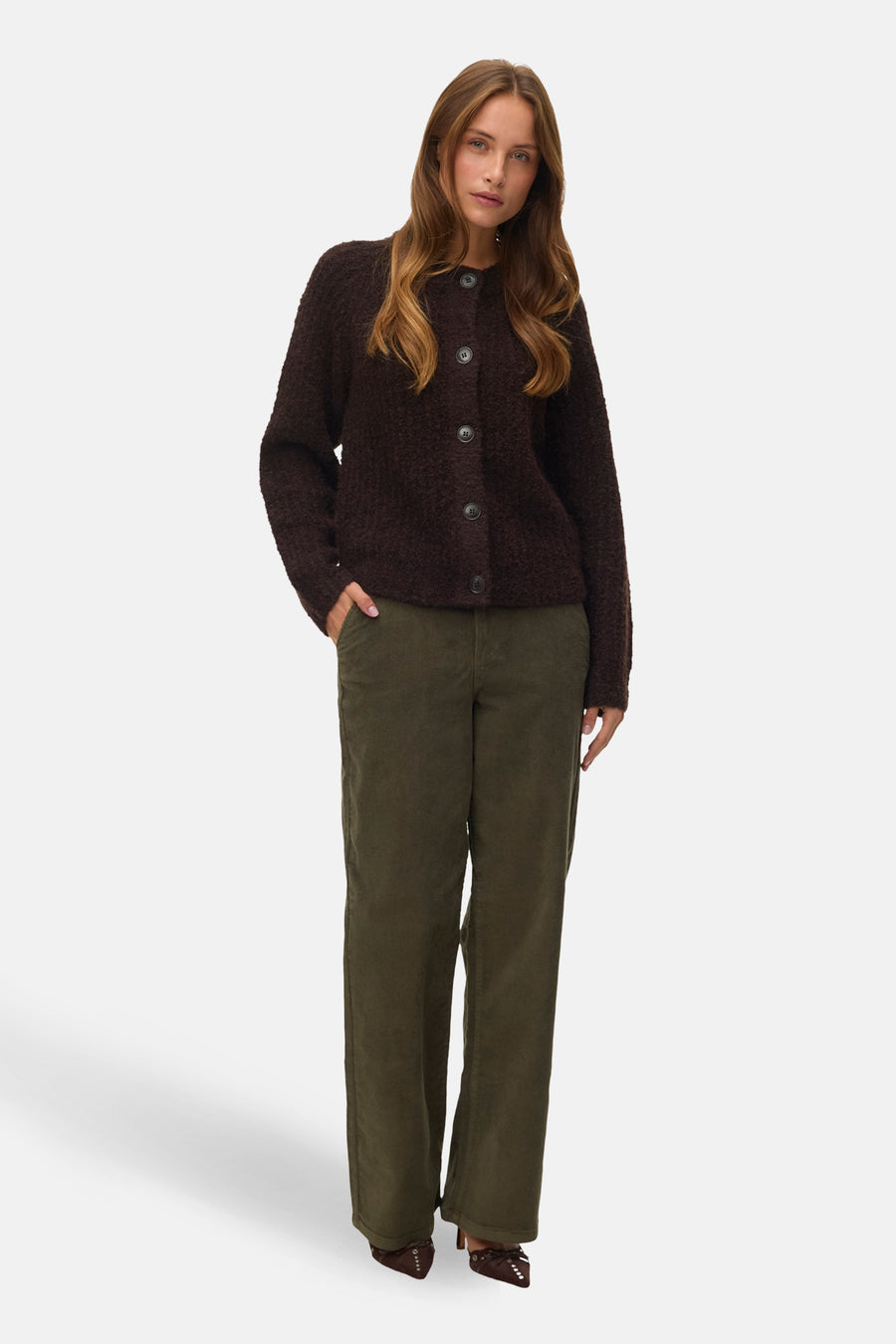 Bruine vest met knopen van VERO MODA, met een gebreide textuur en gedragen met een groene broek.