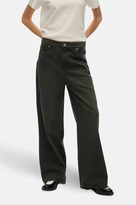 Gekleurde groene jeans van Vero Moda, gedragen met een wit T-shirt en zwarte lakleren schoenen.