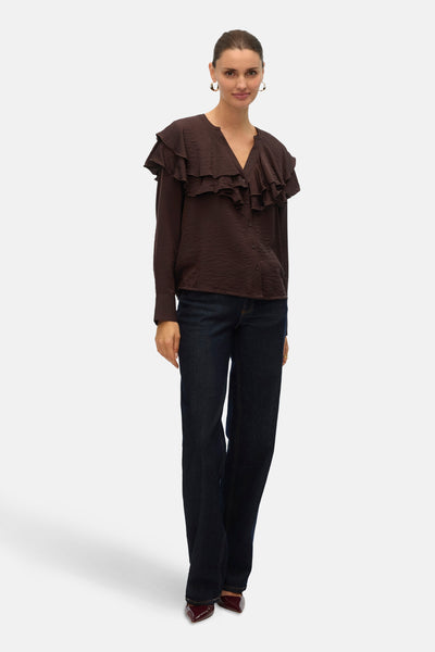 Bruin overhemd met lange mouwen van VERO MODA® met decoratieve ruches, gedragen met een donkerblauwe jeans en bordeauxrode pumps.