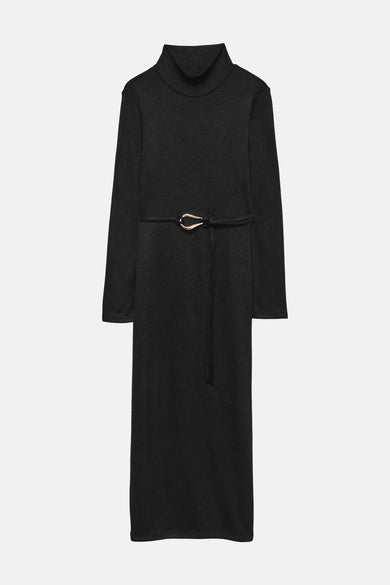 Zwarte jurk van VERO MODA, met gouden strikceintuur en zwarte hakken.