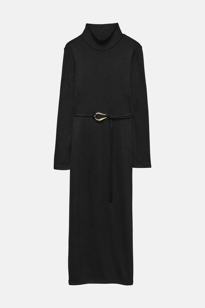Zwarte jurk van VERO MODA, met gouden strikceintuur en zwarte hakken.
