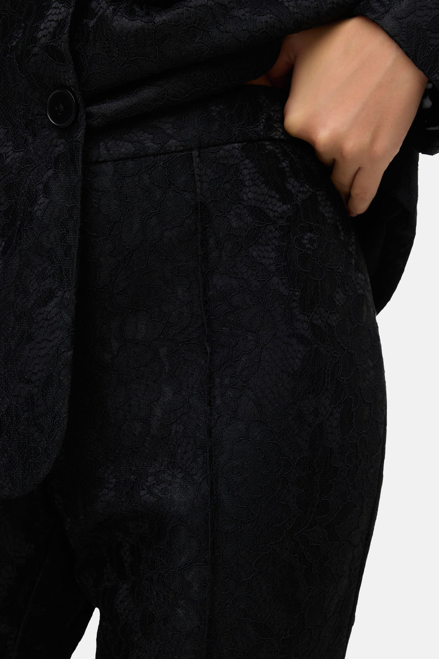 Zwarte broek van VERO MODA in bloemenkant, hand in zak.