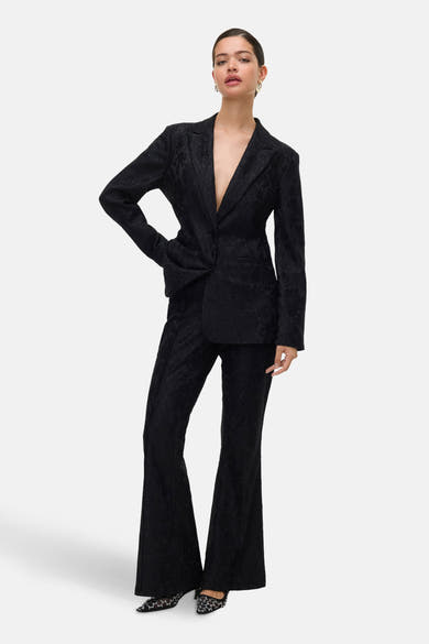Zwarte broek van VERO MODA, met toon-op-toon bloemenpatroon en uitlopende pijpen.