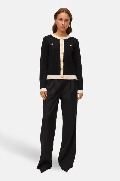 Zwart gilet van VERO MODA, met een crèmekleurige bies en gouden knopen, gedragen met een wijde zwarte broek.
