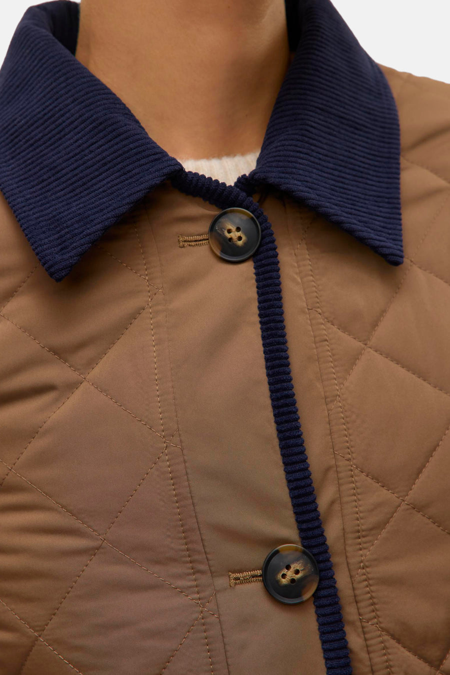 Veste courte marron de VERO MODA avec col et bordures en velours côtelé bleu marine, motif matelassé losanges.