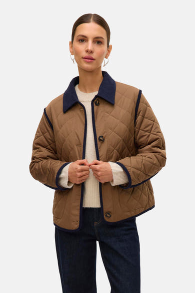Veste courte marron de VERO MODA avec col en velours côtelé bleu marine, motif matelassé et finitions bordées.
