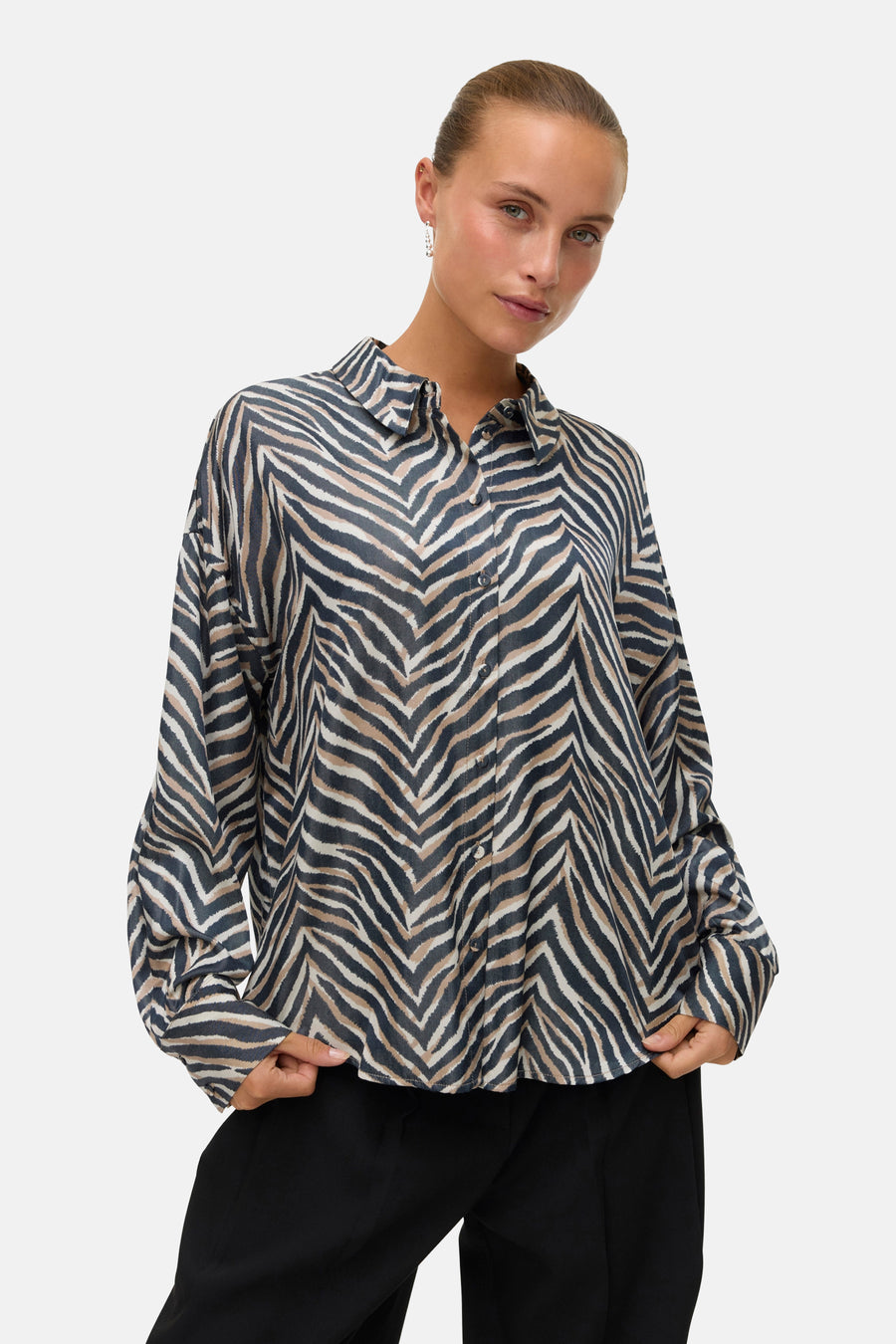 Chemisier multicolore à manches longues de Vero Moda, avec un imprimé zébré et porté avec un pantalon noir.
