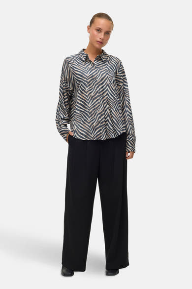 Chemisier à manches longues multicolore de VERO MODA, motif zébré porté avec un pantalon noir à jambes larges.
