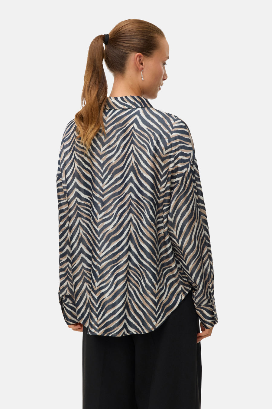 Chemisier à manches longues multicolore de VERO MODA, avec un motif zébré, porté avec un pantalon noir.
