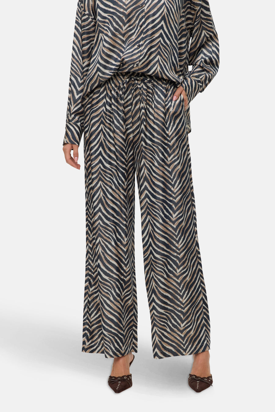 Multikleurige wijde broek van VERO MODA, met zebraprint, gedragen met bruine hakken.