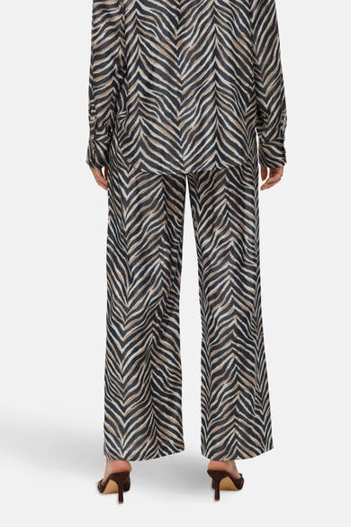 Pantalon large multicolore de VERO MODA, à motif zébré, porté avec des talons marrons.
