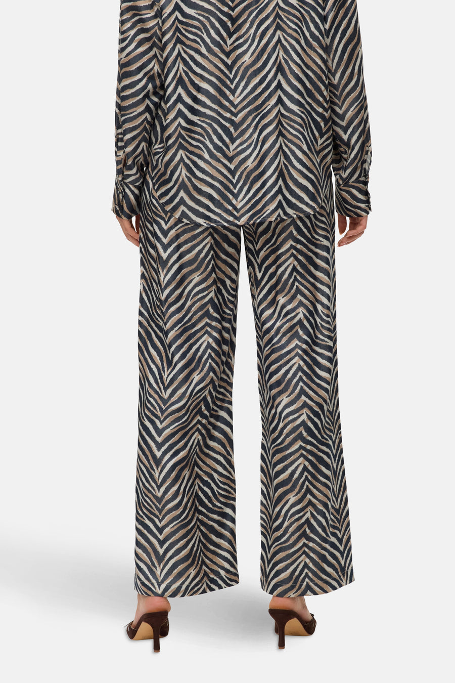 Pantalon large multicolore de VERO MODA, à motif zébré, porté avec des talons marrons.
