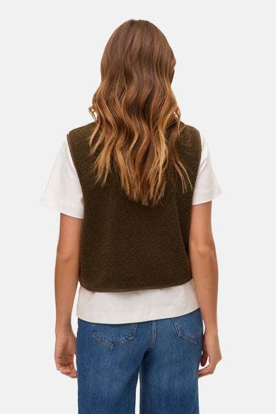 Groen fleecevest van VERO MODA®, gedragen over een wit T-shirt en een blauwe spijkerbroek.