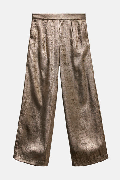 Gouden broek van Vero Moda, wijde pasvorm en glanzende textuurstof.