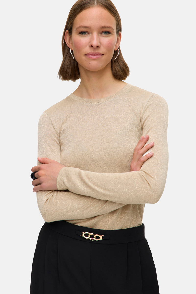 Beige T-shirt met lange mouwen van Vero Moda, gedragen met een zwarte rok met gouden gesp.