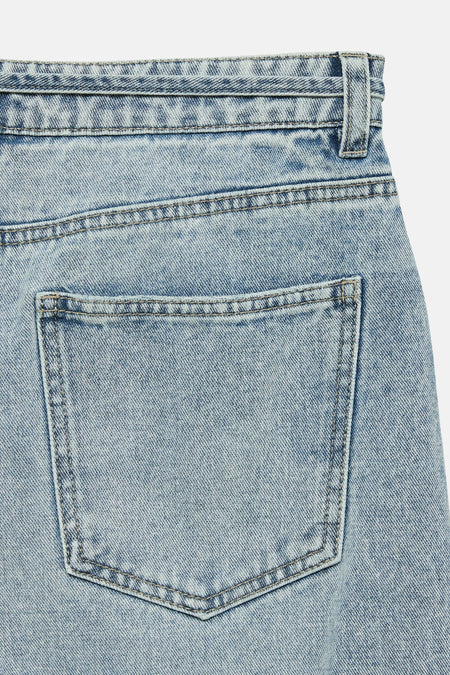 Jean large en denim bleu clair de VERO MODA, détail de la poche arrière et passants de ceinture.
