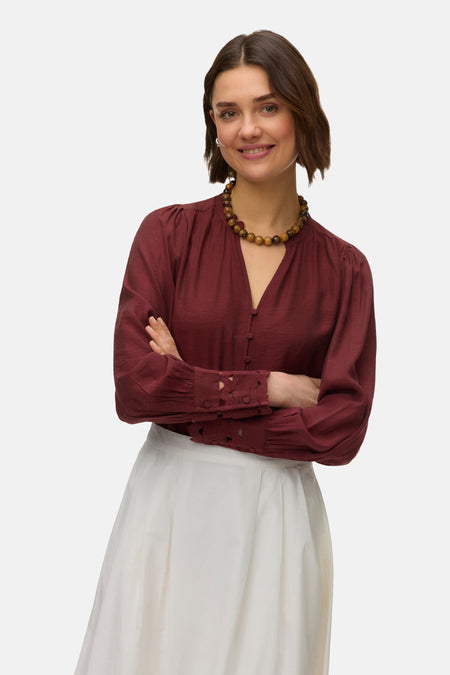 Chemisier à manches longues brique de Vero Moda, avec une encolure en V et des poignets décoratifs.