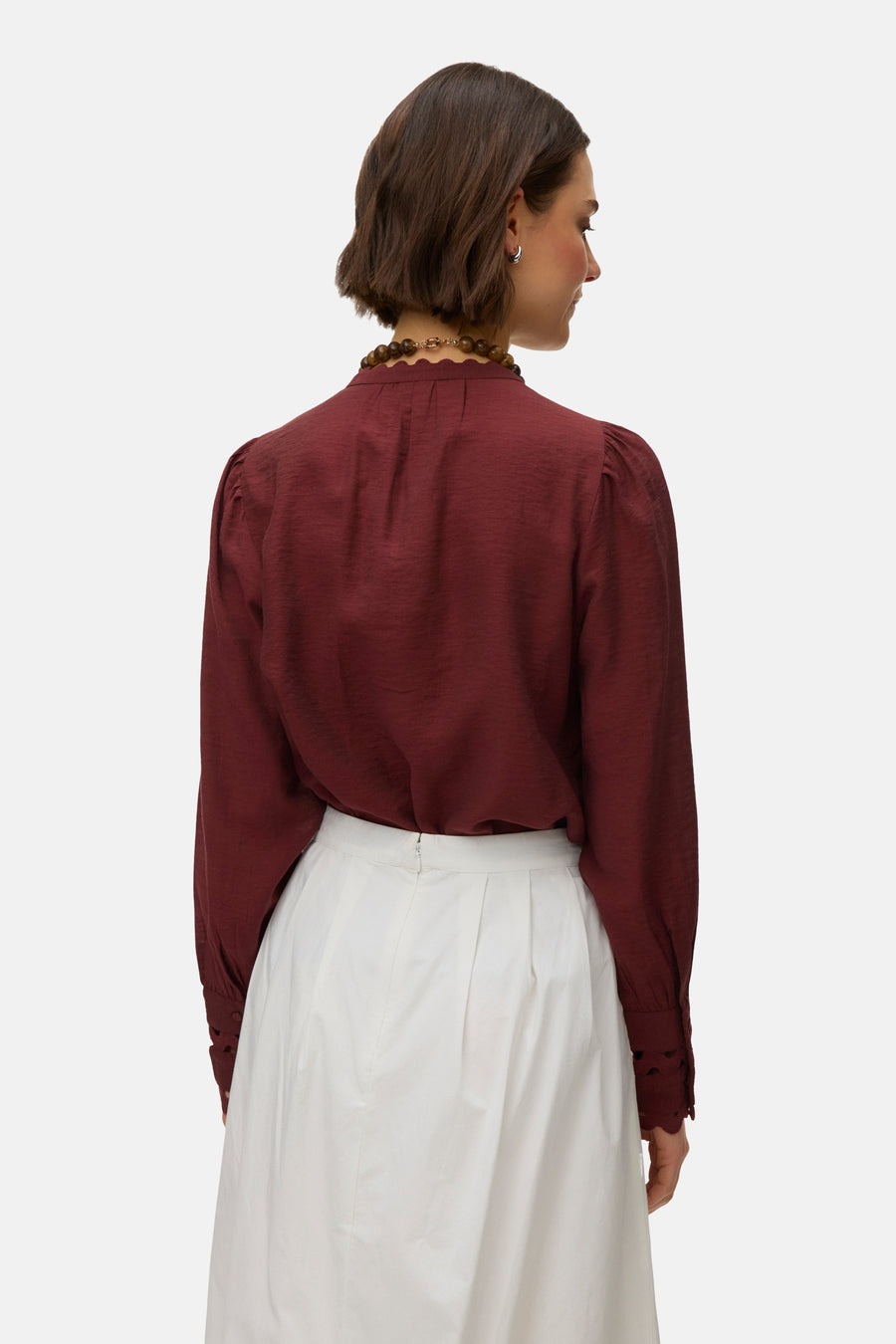 Bakstenen blouse met lange mouwen van VERO MODA®, met opstaande golvende kraag en witte rok.