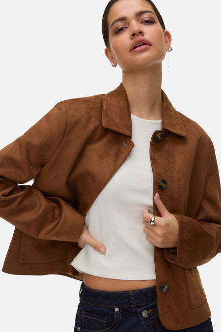Veste courte cognac de Vero Moda, avec boutons marron et portée sur un t-shirt blanc et un jean.