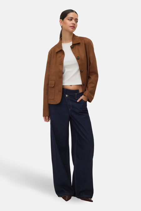 Veste courte cognac de VERO MODA, portée avec un t-shirt blanc court et un jean taille haute bleu marine.