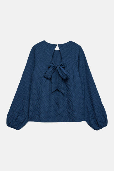 Blouse à manches longues bleue de VERO MODA®, dos ouvert avec un nœud décoratif.
