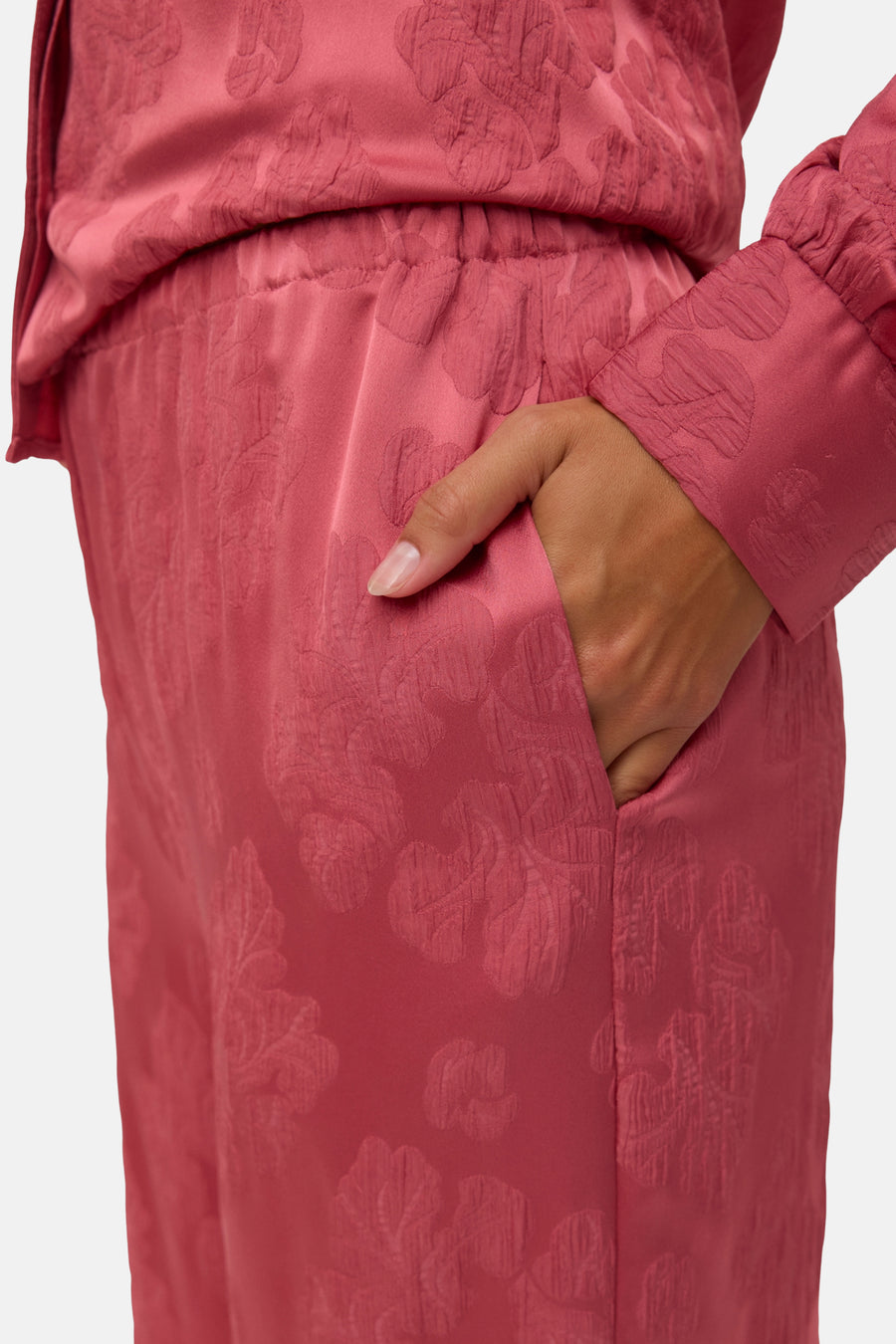 Pantalon rose de VERO MODA, à motif floral texturé, avec une main dans la poche, coupe décontractée.
