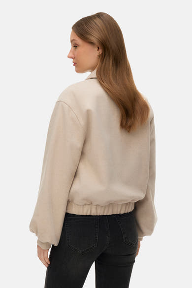 Veste courte écru de VERO MODA, avec manches longues, ourlet élastique, portée avec un jean noir
