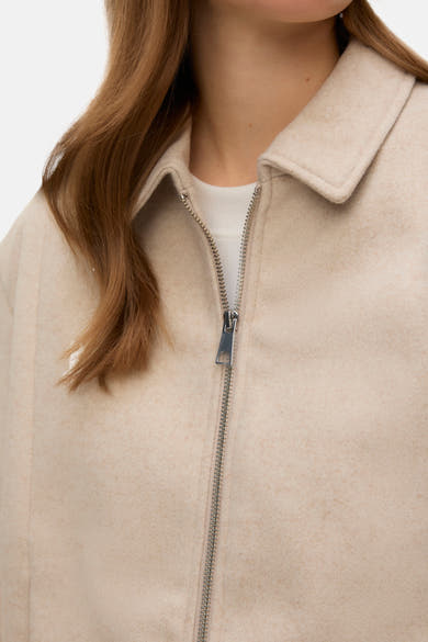 Veste courte écru de VERO MODA, avec fermeture éclair argentée et col classique.