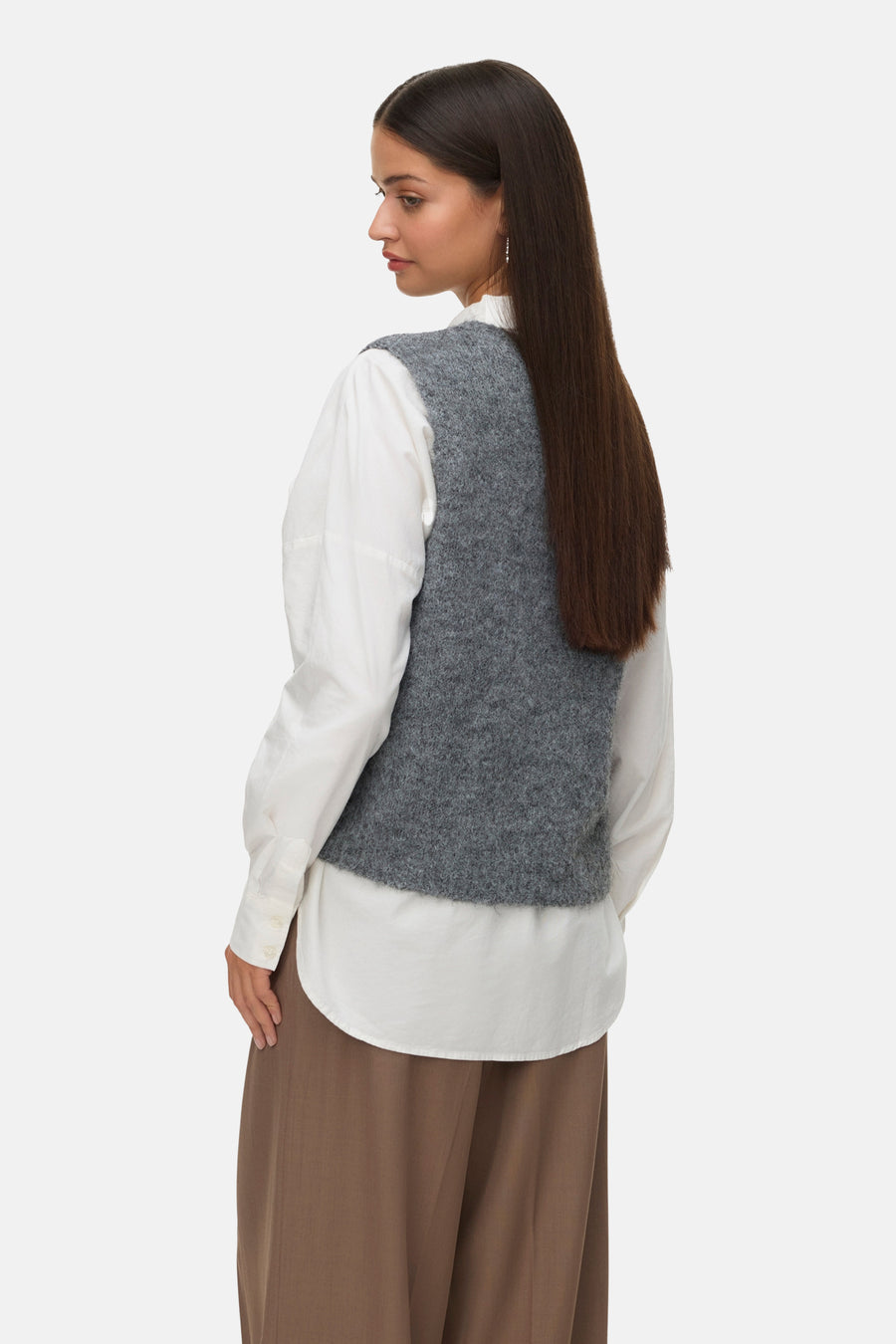 Débardeur gris de VERO MODA, porté sur une chemise blanche boutonnée et un pantalon marron.