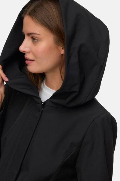 Veste courte noire de VERO MODA, avec une capuche ample et une fermeture zippée, portée sur un t-shirt blanc.