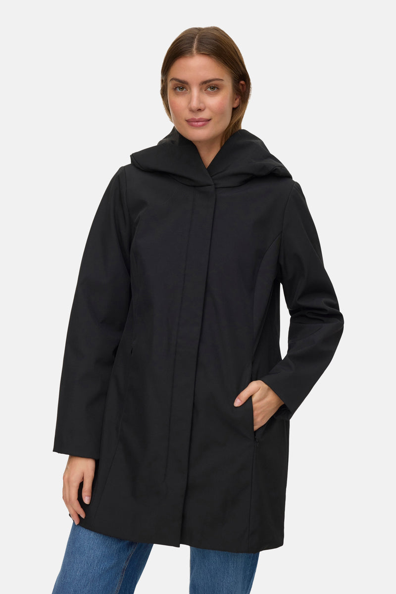 Zwarte jas van VERO MODA, met capuchon en zijzak, gedragen met een blauwe jeans.