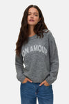Grijze trui met ronde hals van VERO MODA, met witte letters, gedragen met een blauwe jeans.
