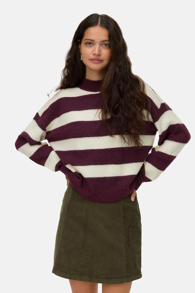 Rode rondehals trui van Vero Moda, contrasterende horizontale strepen, gedragen met een corduroy rok.