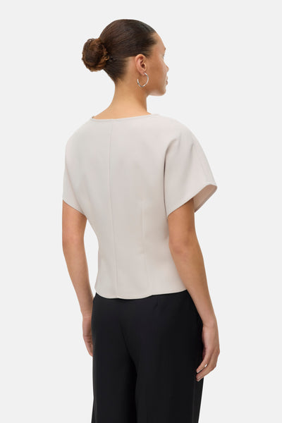 Ecru blouse met korte mouwen van VERO MODA®, achterzijde, gedragen met een zwarte broek.