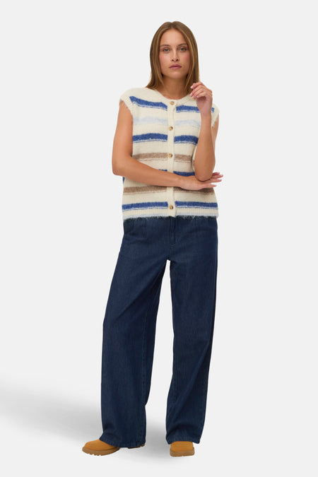 Cardigan tricot multicolore par VERO MODA, avec rayures horizontales, porté avec un jean large et des chaussures marron.
